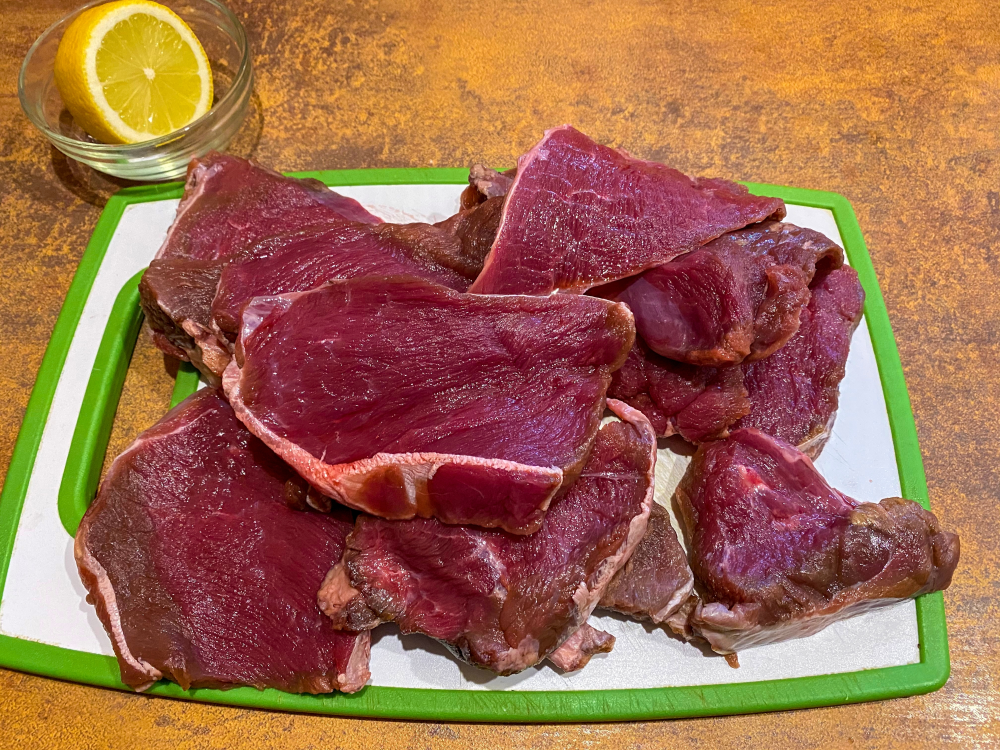 cuts of moose meat on a chopping board cuts of moose meat on a chopping board